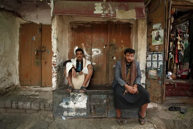 People sit next to closed shops in the old quarter of Yemen's capital Sanaa November 27, 2015. (Photo by Khaled Abdullah/Reuters)
