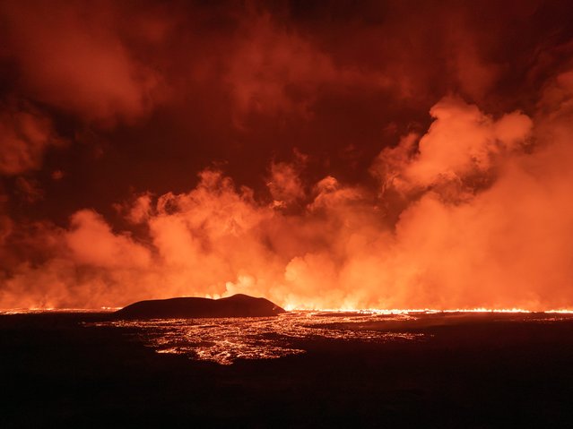 A photo taken during the night from August 22 to 23, 2024 shows lava and smoke erupting from a volcano near Grindavik on the Icelandic peninsula of Reykjanes. A new volcano erupted on the Reykjanes peninsula in southwestern Iceland on August 22, 2024, spewing hot lava into the air in the sixth eruption to hit the region since December 2023, authorities said. (Photo by Ael Kermarec/AFP Photo)