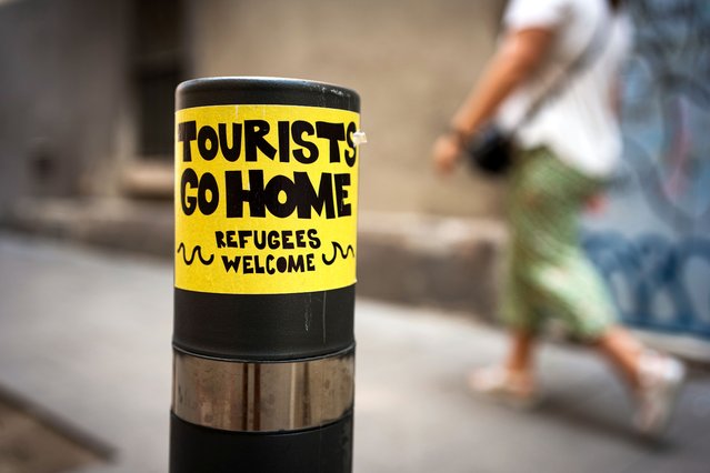 A graffiti reading “tourists go home” is seen on a wall in the city center Barcelona, Spain on August 21, 2024. With more than 18 million tourists expected to visit Barcelona in 2024, the city is struggling to find a balance between the economic benefits of tourism during the tourist season, and the need to keep the city liveable for local residents, who are showing hostility towards the mass tourism and the exploitation of the city by the tourism industry. (Photo by Davide Bonaldo/SOPA Images/Rex Features/Shutterstock)
