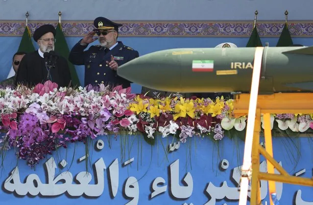 Iranian President Ebrahim Raisi, left, listens to the army's air force commander Gen. Hamid Vahedi as he reviews an army parade commemorating Army Day while a missile is carried on a truck in front of the mausoleum of the late revolutionary founder Ayatollah Khomeini just outside Tehran, Iran, Tuesday, April 18, 2023. President Raisi reiterated threats against Israel while though he stayed away from criticizing Saudi Arabia as Tehran seeks a détente with the kingdom. (Photo by Vahid Salemi/AP Photo)
