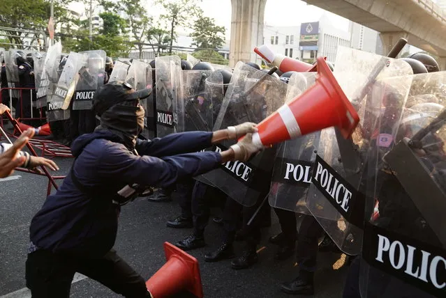 Anti-Thai government protester wields a traffic cone at riot police during a clash at a rally for Myanmar's democracy outside the embassy, in Bangkok, Thailand February 1, 2021. (Photo by Athit Perawongmetha/Reuters)