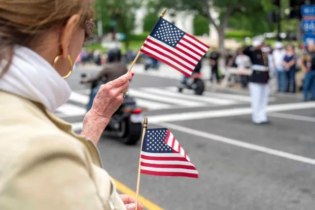 People wave flags during the “Rolling to Remember” motorcycle rally, successor to “Rolling Thunder” as it rides through to bring attention to issues faced by veterans, in Washington, U.S., May 28, 2023. (Photo by Bonnie Cash/Reuters)
