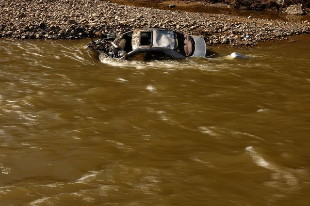 A destroyed car at the Biala Ladecka River lies submerged after flooding in Zelazno, Poland on September 20, 2024. (Photo by Kacper Pempel/Reuters)