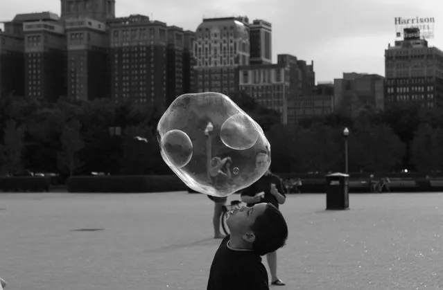 “Double, No, Triple Bubble”. While biking in the city of Chicago my significant other and I stopped to watch a street performer create giant bubbles. The bubbles were attracting adults and kids alike. I nearly got trampled by the wild children chasing the floating soap. I caught a few myself as well as some decent shots. (Photo and caption by Sarah Yost/National Geographic Traveler Photo Contest)
