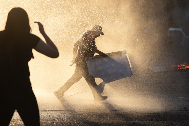 People clash with police during a protest marking the fifth anniversary of the 2019 protests over social inequality, in Santiago, Chile, 18 October 2024. (Photo by Ailen Díaz/EPA)