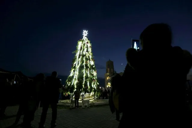 People take pictures during a celebration of the lighting of a 12-metre-tall Christmas tree at a Lutheran Church, which stands on a baptism site on the Jordan River, in Shouneh December 13, 2015. (Photo by Muhammad Hamed/Reuters)