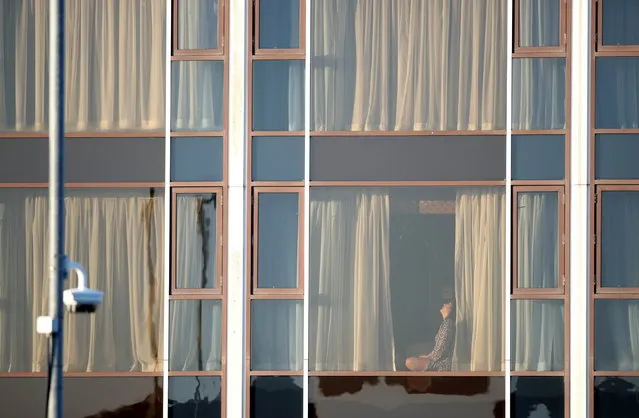 A woman sits at a window at the Radisson Blu Hotel at Heathrow Airport, as Britain introduces a hotel quarantine programme for arrivals from a “red list” of 30 countries due to the coronavirus disease (COVID-19) pandemic, Britain, February 26, 2021. (Photo by Peter Cziborra/Reuters)
