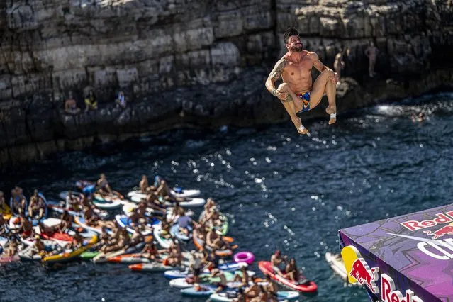 In this handout image provided by Red Bull, Carlos Gimeno of Spain dives from the 27.5 metre platform during the final competition day of the third stop of the Red Bull Cliff Diving World Series on July 02, 2023 at Polignano a Mare, Italy. (Photo by Dean Treml/Red Bull via Getty Images)