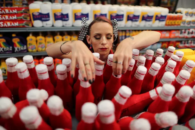 British artist Lucy Sparrow, adjusts bottles of ketchup in a art installation supermarket in which everything is made of felt, in Los Angeles, California on July 31, 2018. (Photo by Lucy Nicholson/Reuters)