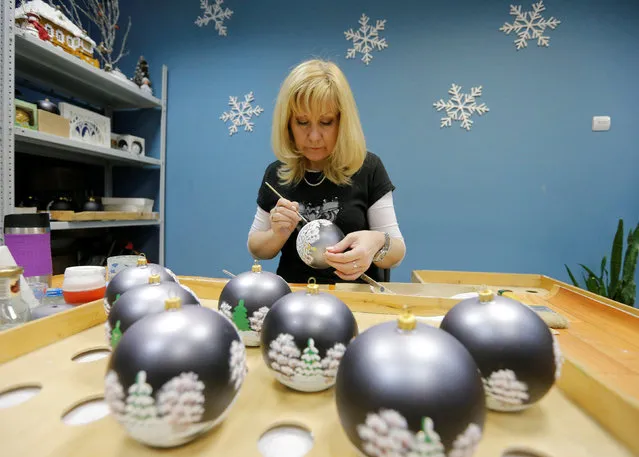 An employee paints a glass Christmas and New Year decoration at the “Yolochka” (Christmas tree) factory, which has been producing glass decorations and toys for the festive season since 1848, in the town of Klin outside Moscow, Russia, November 24, 2016. (Photo by Maxim Zmeyev/Reuters)