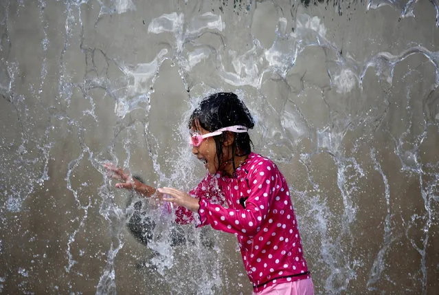 A girl plays in a fountain to cool down at a park during a hot summer day in Tokyo, Japan, July 26, 2018. (Photo by Kim Kyung-Hoon/Reuters)
