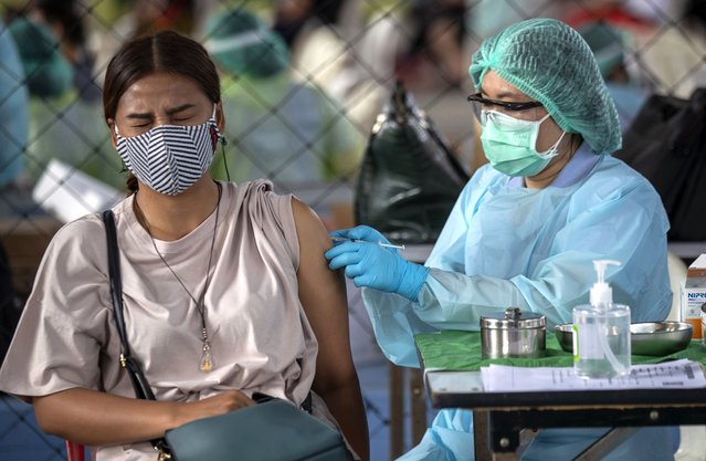 A health worker administers a dose of the Sinovac COVID-19 vaccine to a worker in a local entertainment venue area where a new cluster of COVID-19 infections were found in Bangkok, Thailand, Wednesday, April 7, 2021. Officials in Thailand’s capital have ordered a two-week closure of all entertainment venues in three districts to try to limit the spread of the coronavirus from nightspots there. (Photo by Sakchai Lalit/AP Photo)