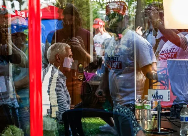 Reflections of Iowa fairgoers wearing tee-shirts supporting former U.S. President Donald Trump are reflected in a window as U.S. Republican presidential candidate and former Vice President Mike Pence gives an interview at the Iowa State Fair in Des Moines, Iowa, August 10, 2023. (Photo by Evelyn Hockstein/Reuters)