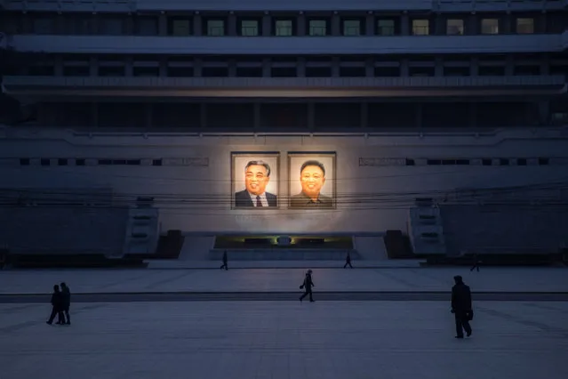 Pedestrians make their way past the portraits of late North Korean leaders Kim Il-Sung (L) and Kim Jong-Il (R) in Pyongyang on December 1, 2016. The United Nations Security Council unanimously imposed its toughest sanctions on North Korea, placing a cap on the hermit state's key coal exports after its defiant nuclear tests. (Photo by Ed Jones/AFP Photo)