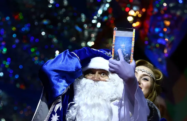 People dressed as Father Frost, the equivalent of Santa Claus, and Snow Maiden take a selfie as they take part in the contest “Yolka-fest-2016” (Fir-festival-2016) in Minsk, Belarus December 9, 2016. (Photo by Vasily Fedosenko/Reuters)