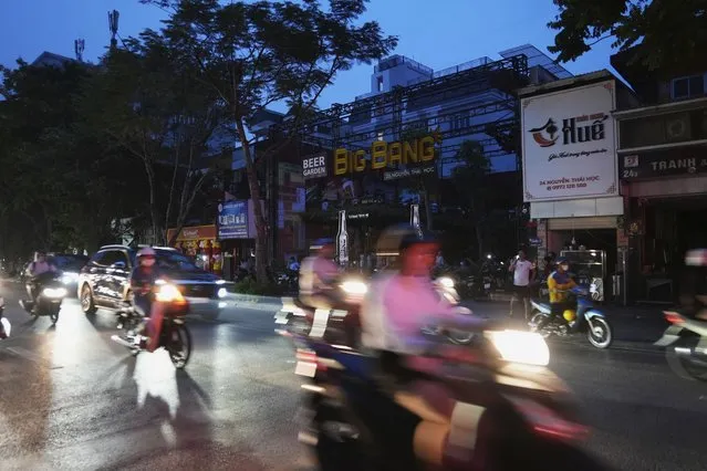 Drivers and motorcyclists move through a street during a blackout in Hanoi, Vietnam, on June 8, 2023. Vietnam has released a long-anticipated energy plan meant to take the country through the next decade and help meet soaring demand while reducing carbon emissions. (Photo by Hau Dinh/AP Photo)