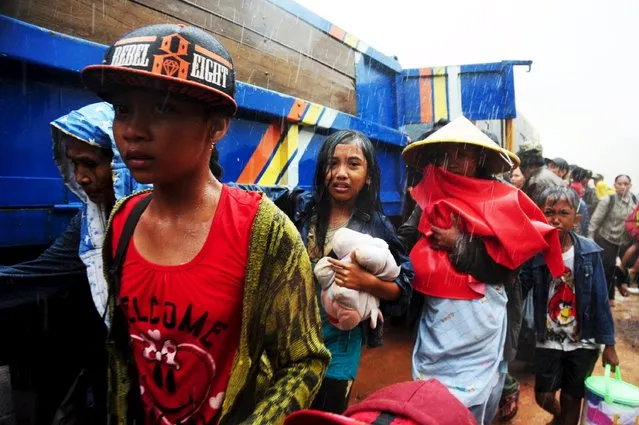 Members of the Gafatar sect walk in the rain as they evacuate their compound, which was later burned down by local villagers, in Antibar village, Mempawah Regency, Indonesia West Kalimantan Province, January 19, 2016 in this photo taken by Antara Foto. Local authorities and police moved the sect members to an army barracks located some 70 km (43 miles) away from Antibar for their safety following recent disputes between the sect and the villagers, Antara said on Tuesday. (Photo by Jessica Helena Wuysang/Reuters/Antara Foto)