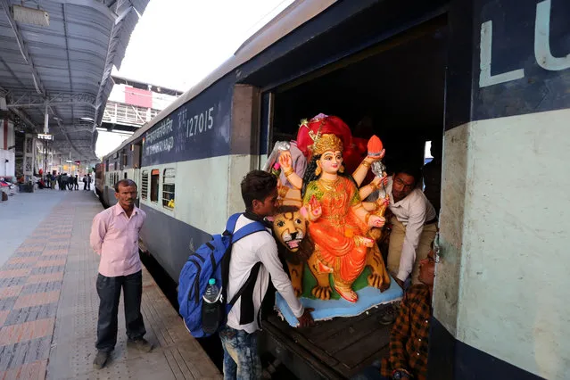 Hindu devotees carry an idol of the Goddess Durga in a train and later to be set up in a Puja pandal on the eve of Navratri festival in Bhopal, India, 09 October 2018. The annual Hindu nine-day festival of worship and dance will run from 10 October onwards. (Photo by Sanjeev Gupta/EPA/EFE)