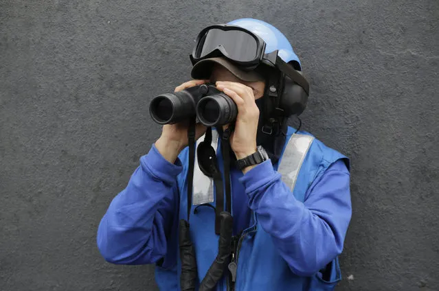 In this Tuesday, March 17, 2015 photo, a French sailor looks with binoculars from the flight deck of the French Navy aircraft carrier Charles de Gaulle in the Persian Gulf. (Photo by Hasan Jamali/AP Photo)