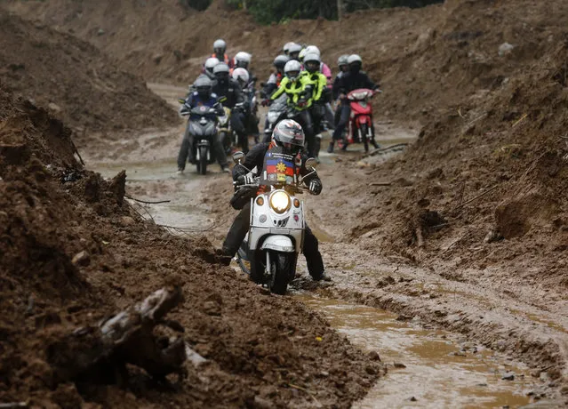Filipino motorcycle riders maneuver on a landslide as they travel to a relief operation conducted by motorcycle group “Ride For A Cause (RFAC)” at a landslide hit village in the mountains of Sierra Madre, Infanta township, Quezon province, Philippines, 31 January 2016. Hundreds of RFAC volunteer motorcycle riders brought relief goods amid affected villagers appealed to government for help to clear away debris on the roads for the passage of relief goods. Landslides and floodwaters affected the transport of relief goods in many villages brought by recent typhoon, according to government civil defense office. (Photo by Francis R. Malasig/EPA)