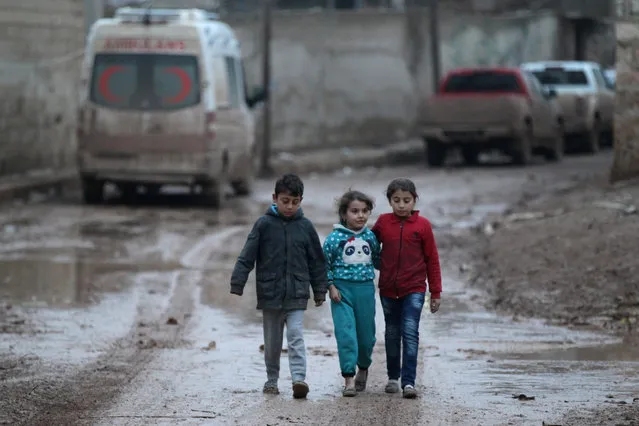 Children walk near a parked ambulance in al-Rai town, northern Aleppo province, Syria December 27, 2016. (Photo by Khalid al Mousily/Reuters)