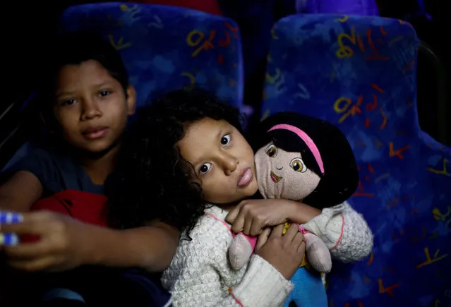 A migrant girl, part of a caravan of thousands traveling from Central America to the United States, hugs her doll on a bus bound for Mexicali at a makeshift camp in Navojoa, Mexico November 17, 2018. (Photo by Kim Kyung-Hoon/Reuters)