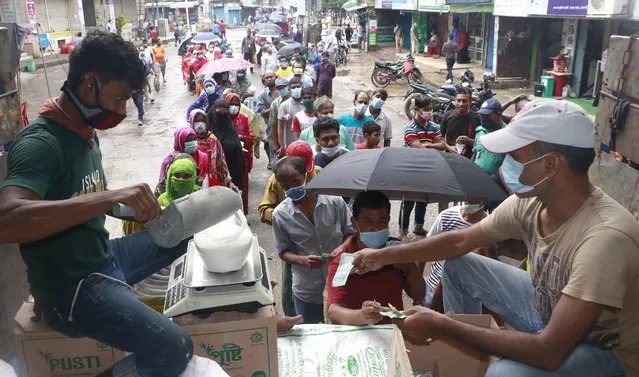 People line up to receive ration without maintaining social distancing in Rajshahi, 254 kilometers (158 miles) north of the capital, Dhaka, Bangladesh, June 16, 2021. (Photo by Kabir Tuhin/AP Photo)