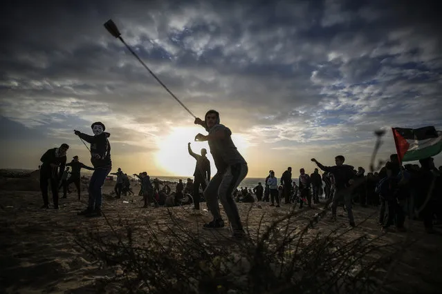 Palestinians throw stones with slingshots in response to Israeli forces' intervention with gas bombs during maritime protest against Israels ongoing blockade of Gaza on the strips northern coast, in Gaza on December 17, 2018. They demand an end to Israels 12-year blockade of the strip, which has gutted Gazas economy and deprived its roughly 2 million inhabitants of many basic commodities. (Photo by Ali Jadallah/Anadolu Agency/Getty Images)