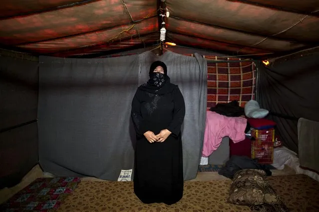 In this Monday, March 16, 2015 photo, Syrian refugee Huda Alhumaidi, 30, a mother of six children who is four months pregnant, poses for a portrait inside her tent at an informal settlement near the Syrian border, on the outskirts of Mafraq, Jordan. (Photo by Muhammed Muheisen/AP Photo)