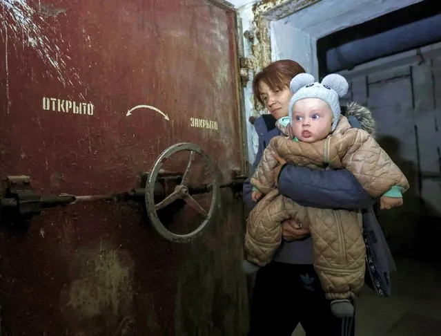 Zhenia, 6-months-old and his mother, Olha Shevchenko, 39, in a bomb shelter in Kharkiv, Ukraine on October 13, 2022. Zhenia has lived in a bomb shelter since he was born. (Photo by Vyacheslav Madiyevskyy/Reuters)