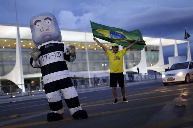 A man waves a Brazilian national flag near an inflatable doll meant to represent former Brazilian president Luiz Inacio Lula da Silva during a protest against Lula following his brief detention for questioning in a federal investigation of a vast corruption scheme, in front of Planalto Palace in Brasilia, Brazil, March 4, 2016. (Photo by Ueslei Marcelino/Reuters)