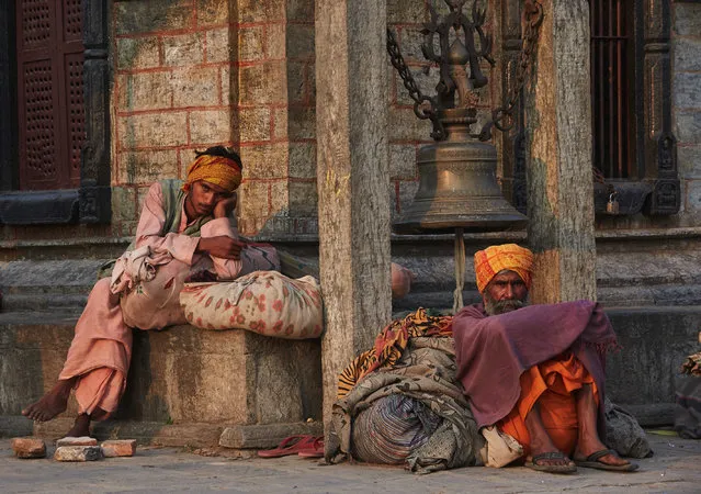 Two holy men sit by a building with their possessions, taken in Kathmandu, Nepal. (Photo by Jan Moeller Hansen/Barcroft Images)