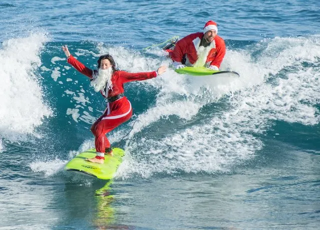 Surfing Santas on the city beach in Las Palmas on Gran Canaria, Canary Islands, Spain on December 20, 2022. (Photo by Alan Dawson/Alamy Live News)