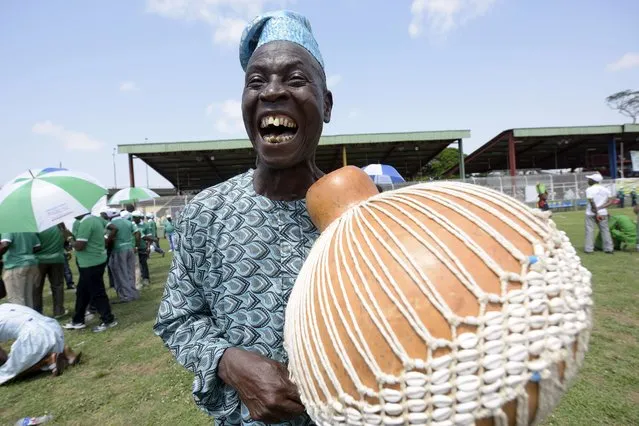 A man entertains with a traditional musical instrument during a Labour Day rally in Lagos on May 1, 2015. Tens of thousands of people across the globe were hitting the streets on May 1 for mass rallies marking International Labour Day. (Photo by Pius Utomi Ekpei/AFP Photo)