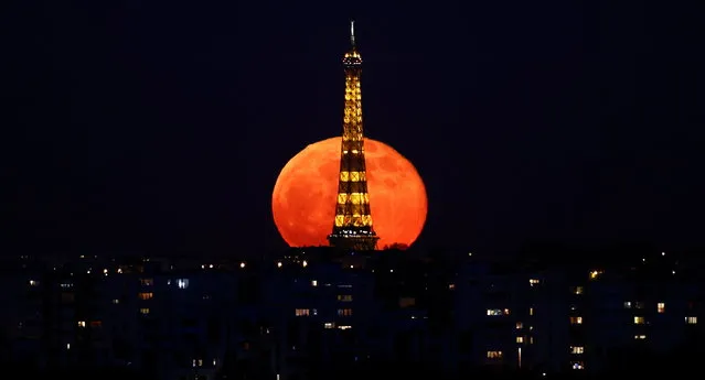 The full moon, known as the “Super Pink Moon” rises behind the Eiffel Tower during a nationwide curfew due to tighter measures against the spread of the coronavirus disease (COVID-19) in Paris, France, April 27, 2021. (Photo by Christian Hartmann/Reuters)