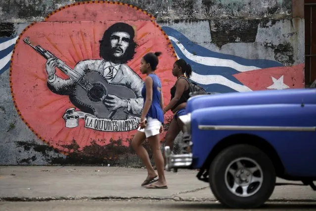 Women walk past a painting of the late revolutionary hero Ernesto “Che” Guevara in Havana, Cuba March 19, 2016. (Photo by Ueslei Marcelino/Reuters)