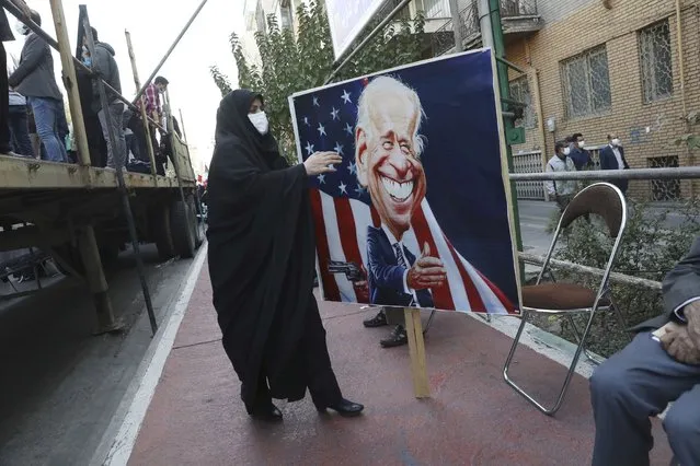A demonstrator carries a banner with a caricature of the U.S. President Joe Biden in a rally in front of the former U.S. Embassy commemorating the anniversary of its 1979 seizure in Tehran, Iran, Thursday, November 4, 2021. (Photo by Vahid Salemi/AP Photo)