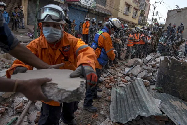 Nepalese military personnel remove debris in search of survivors after a fresh 7.3 earthquake struck, in Kathmandu, Nepal, May 12, 2015. (Photo by Athit Perawongmetha/Reuters)