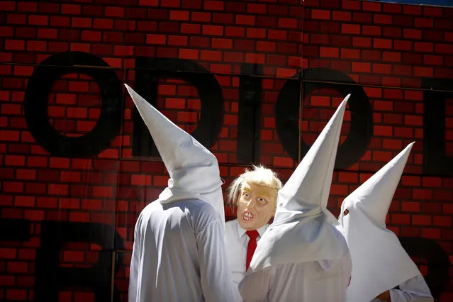 Actors impersonating U.S. President Donald Trump and members of the Ku Klux Klan stage a performance on behalf of a local Mexican political party during a protest against Trump, in Mexico City, Mexico February 20, 2017. The writing on the mock wall reads “Hatred”. (Photo by Jose Luis Gonzalez/Reuters)