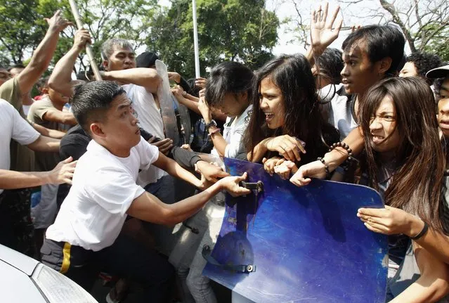 Members of the Presidential Security Groups (PSG) use shields and a baton to push back student activists (R) who protested ahead of the International Women's Day at the Malacanang presidential palace ground in Manila March 6, 2014. On March 8 activists around the globe celebrate International Women's day, a holiday that dates back to the beginning of the 20th Century and has been observed by the United Nations since 1975. (Photo by Romeo Ranoco/Reuters)