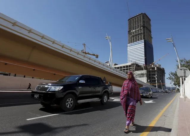 The construction site of the Bharia Icon 62 story building is seen in the background as a woman walks along a street in Karachi, Pakistan, February 9, 2016. Karachi property prices jumped 23 percent last year to a record high, outpacing other large cities and the national average of 10 percent, data from property website Zameen.com showed. (Photo by Akhtar Soomro/Reuters)