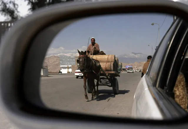 An Afghan man riding a horse drawn cart is seen reflected in the mirror of a car in the city of Jalalabad, the provincial capital of Nangarhar province, Afghanistan Tuesday, February 17, 2009. (Photo by Rahmat Gul/AP Photo)