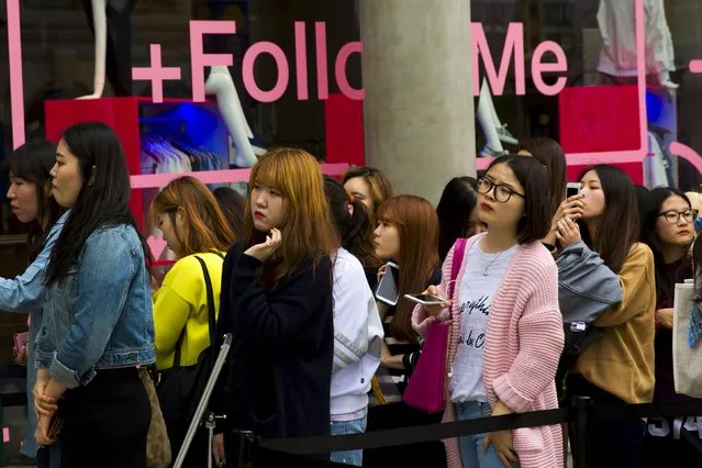 Women wait in line for the opening of an upmarket boutique in the fashion district of Apgujeong in Seoul, May 7, 2015. (Photo by Thomas Peter/Reuters)