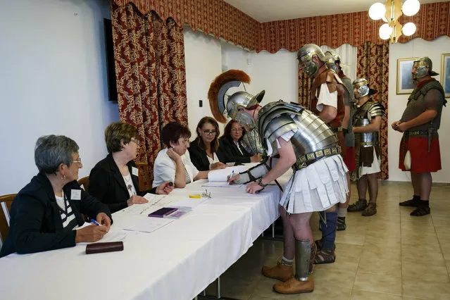 Members of the Colonia Rostallo Cultural and Military History Foundation arrive to cast their vote in ancient Roman legionary costumes during the European elections in a polling station in Nemesvamos, Hungary, Sunday, May 26, 2019. The European Parliament election is held by member countries of the European Union (EU) from May 23 to 26, 2019. (Photo by Gyorgy Varga/MTI via AP Photo)