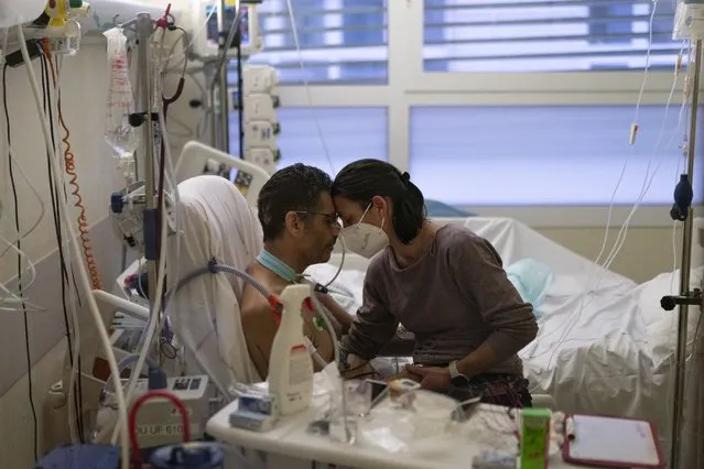 Amelie and Ludo Khayat hold each other during a visit at the COVID-19 intensive care unit of the la Timone hospital in Marseille, southern France, Thursday, December 23, 2021. Ludo, 41 years old, is recovering from spending twenty four days in a coma and on a ventilator in a COVID-19 intensive care unit. Amelie began visiting her husband daily after he started to test negative for the virus. (Photo by Daniel Cole/AP Photo)