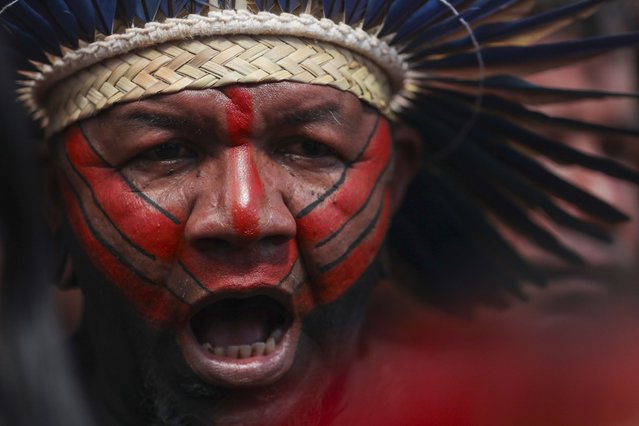 An Indigenous man attends the opening ceremony of the 20th annual Free Land Indigenous Camp in Brasilia, Brazil, April 22, 2024. The 7-day event aims to show the unity of Brazil's Indigenous peoples in their fight for the demarcation of their lands and their rights. (Photo by Luis Nova/AP Photo)
