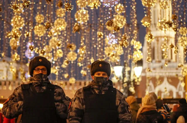 Policemen walk on the street decorated for the upcoming Christmas celebrations amid the Covid-19 coronavirus pandemic in Moscow, Russia, 03 January 2022. Muscovites are preparing to celebrate Christmas which is observed on 07 January, according to the Russian Orthodox Julian calendar 13 days after Christmas on 25 December on the Gregorian calendar. (Photo by Yuri Kochetkov/EPA/EFE)