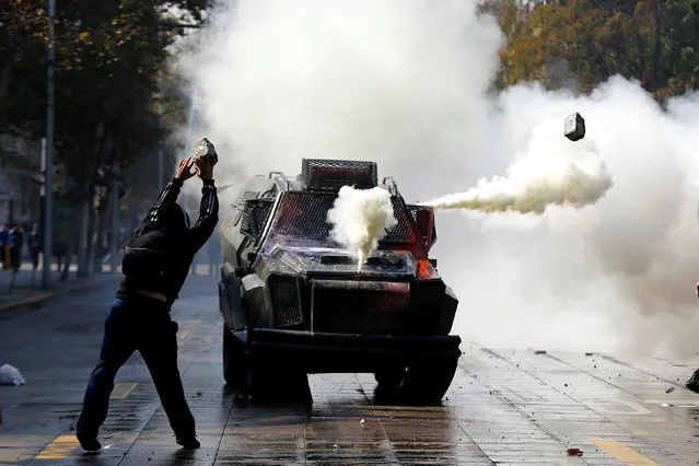A student protester throws a stone against a riot police vehicle during a demonstration to demand changes in the education system in Santiago, Chile, April 21, 2016. (Photo by Ivan Alvarado/Reuters)