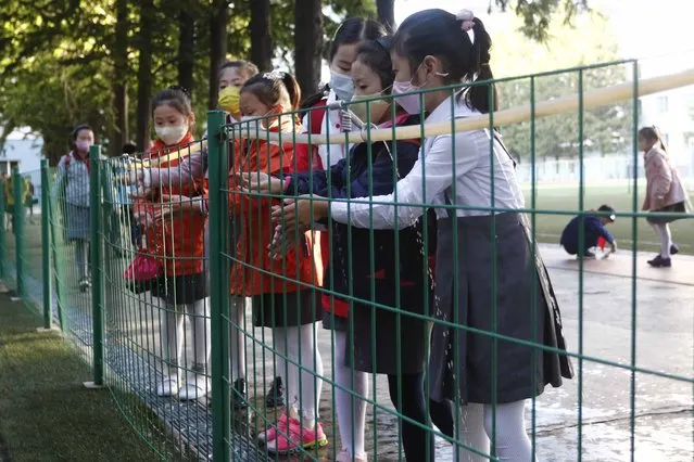 Schoolchildren wash their hands to help curb the spread of the coronavirus before entering Kim Song Ju Primary School in Central District in Pyongyang, North Korea, Wednesday, October 13, 2021. (Photo by Cha Song Ho/AP Photo)