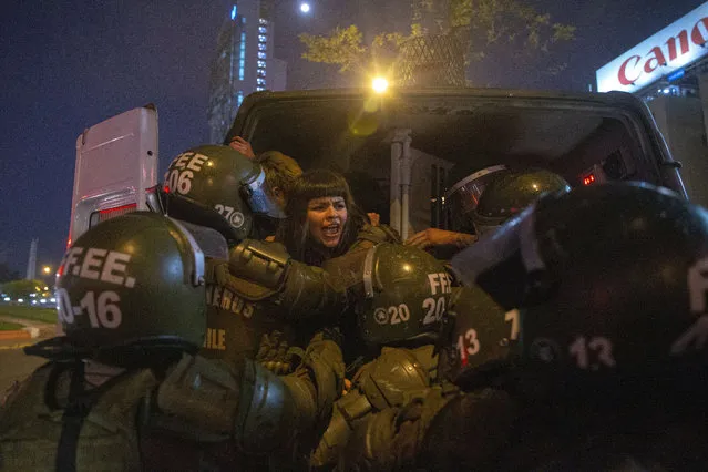 A woman is detained by police during a feminist protest marking the 46th anniversary of the military coup that ousted the late President Salvador Allende, in Santiago, Chile, Wednesday, September 11, 2019. (Photo by Esteban Felix/AP Photo)